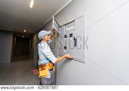 An Electrician Working On An Industrial Breaker Panel. Model Is An Actual Electrician Performing All