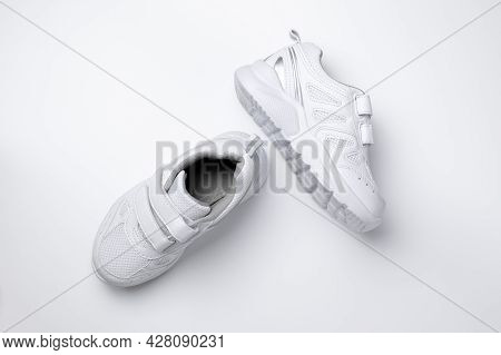 Top View Of Two White Children Sneakers With Velcro Fasteners For Easy Footwear Isolated On A White 