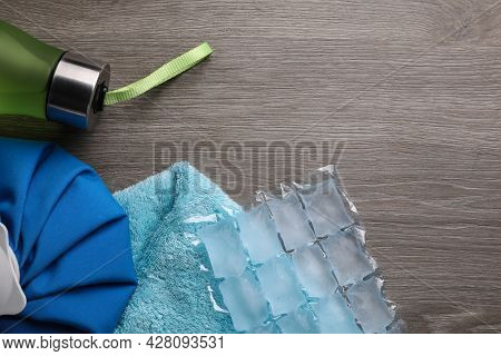Bottle Of Water, Ice Pack, Cold Compress And Towel On Wooden Background, Flat Lay With Space For Tex