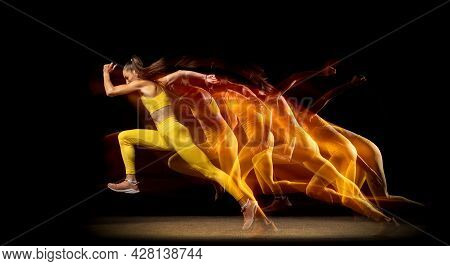 Young Woman, Female Athlete Running Aside Isolated Over Black Studio Background In Mixed Neon Lights