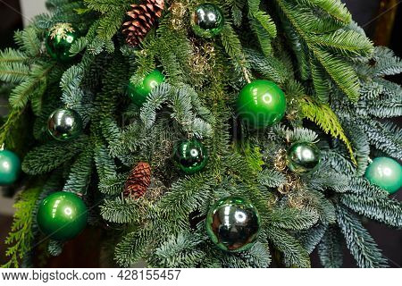 Close-up View Of Beautiful Christmas Tree With Colorful Baubles And Illuminated Garland. Fir Tree De