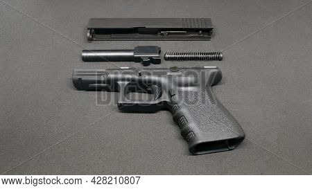 9mm Pistol Is Separated To Pieces On Black Background.