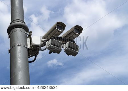 A Pair Of Surveillance Cameras On A Metal Pole