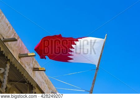 National Flag Of Qatar On A Flagpole In Front Of Blue Sky