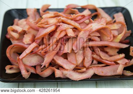 Squid (lat. Teuthida) Half-rings Cut Into Strips On A Black Rectangular Plate With A Wooden Table Ba