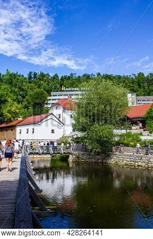 Postojna, Slovenia - July 16, 2017: View Of Tourists Walking Around Postojna With Hotel Jama In The 