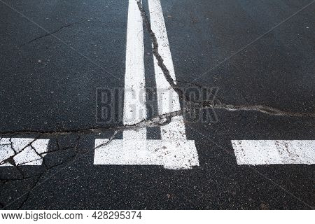 Road With Road Marking Lines. Double Solid White Center Lines. Cracked Asphalt Surface.