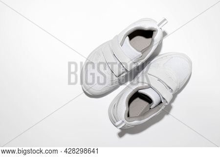 Top View Of White Child Sports Shoes With Velcro With Hard Light Isolated On White Background