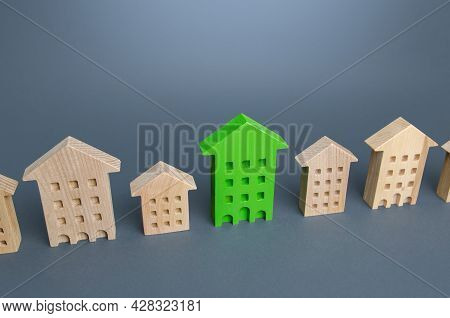 Green Residential Building Among Houses. Environmentally Friendly, Energy Efficient And Zero Carbon 