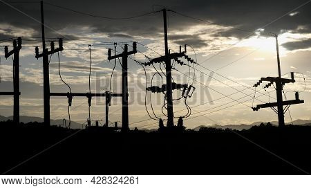 Low Angle View Of Electric Pole Against Sky With The Setting Sun In The Evening