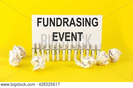 White Paper On Yellow Background With Text Fundrasing Event