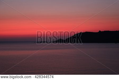 Very Warm Tones Of A Fiery Sunset With The Island And The Sea Without People