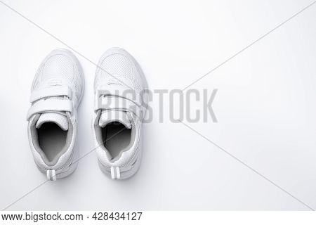 Flat Lay Two White Girl Sneakers With Velcro Fasteners Isolated On A White Background
