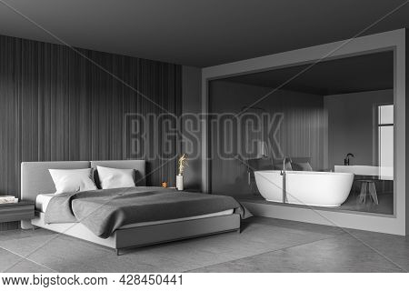 Corner Of The Grey Bedroom Interior With Bed, Wall Panelling, Rug, Shelves, Concrete Floor And Glass