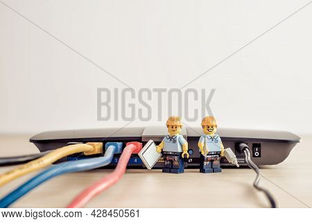 Billund, Denmark - July 15, 2021: Technicians Connecting Network Cable. Illustrative Editorial