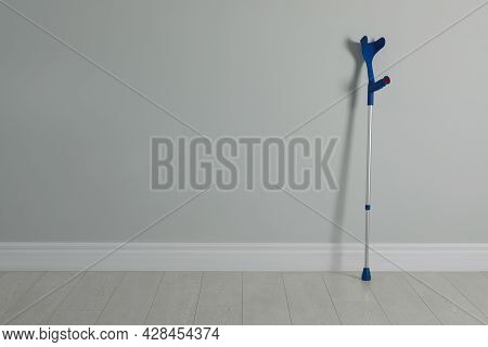 Elbow Crutch Near Light Grey Wall. Space For Text