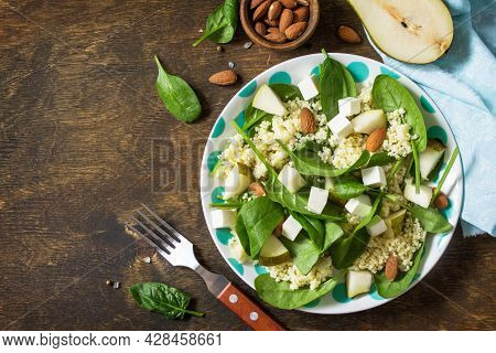 Autumn Fruit Salad. Couscous Salad With Pear, Spinach, Feta Cheese And Vinaigrette Sauce On A Wooden