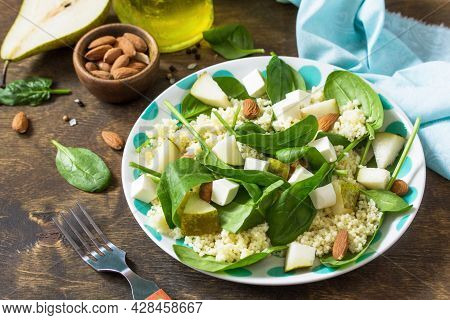 Autumn Fruit Salad. Couscous Salad With Pear, Spinach, Feta Cheese And Vinaigrette Sauce On A Wooden