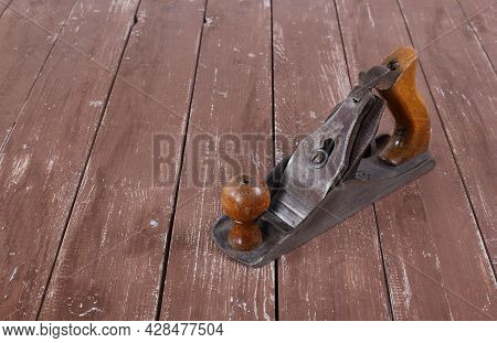 Tools Building And Repair - Old Rusty Metal Hand Plane Closeup A Wooden Background.