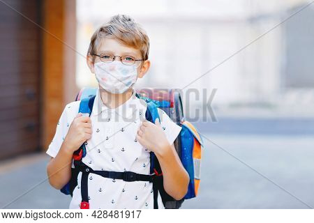 Happy Little Kid Boy With Glasses And Backpack Or Satchel. Schoolkid On The Way To School. Portrait 