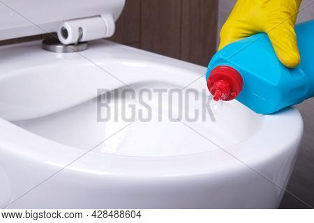 Close-up Cleaning Of  Rimless Toilet, Close-up Hand In  Glove Applies Cleaning Agent To  Toilet Bowl