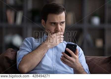 Doubtful Young Man Hold Phone Hesitate Before Make Call