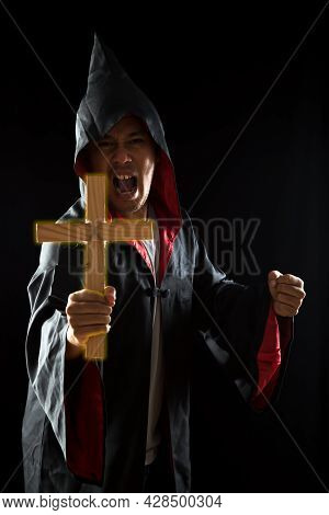 Dark Tone, Rim Light - Young Wizard Show Wooden Lighting Crucifix To Exorcise Ghost On Black Backgro