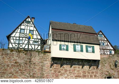 Old House Built Over Medieval City Wall Next To Two Half-timbered Houses In Hirschhorn In Southern G