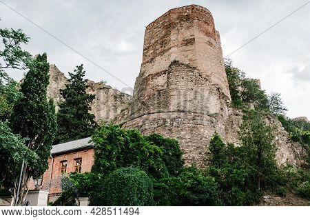 Old City Wall From Stones With Towers Round A City, Ancient Fortress Narikala In The Old Town Of Tbi