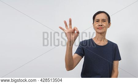 Senior Or Older Asian Woman's Hand Doing A Ok Or Okay Hand Sign On White Background.she Is Black Hai