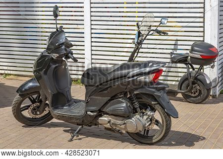 Black City Low-capacity Scooter Stands On The Street