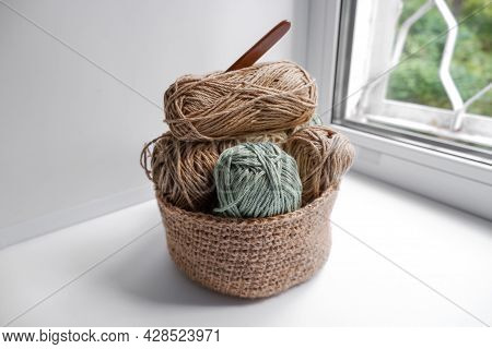 Yarn In A Knitted Basket On A White Background With Hooks. Yarn Of Different Colors. The Concept Of 