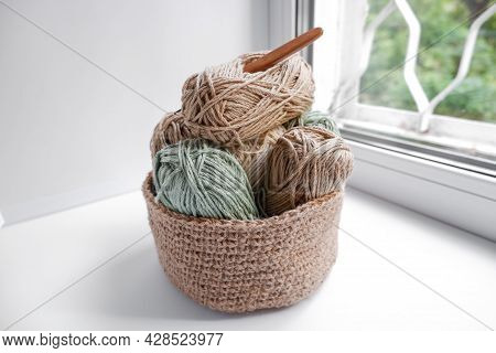 Yarn In A Knitted Basket On A White Background With Hooks. Yarn Of Different Colors. The Concept Of 