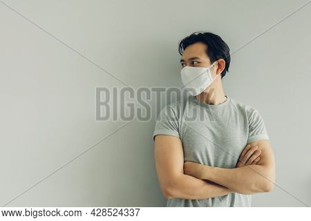 Normal Face Of Asian Man Wearing White Hygienic Mask In Grey T-thirt With Copy Space.