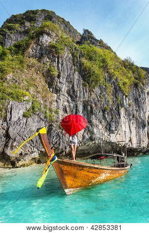 Ragazza con un ombrello rosso su una barca in un Resort