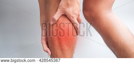 Adult Male With His Muscle Pain On Gray Background. Elderly Man Having Leg Ache Due To Calf Muscle P
