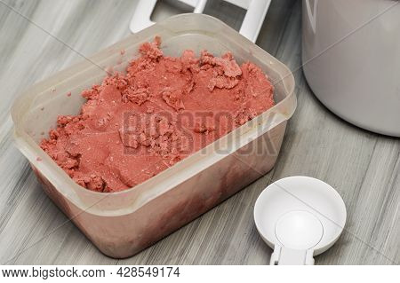 Homemade Cherry Ice Cream In A Plastic Container On The Table Next To An Ice Cream Spoon And An Ice 