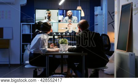 Diverse Group Of Business Teamwork Discussing With Remote Coworkers During Online Videocall Conferen