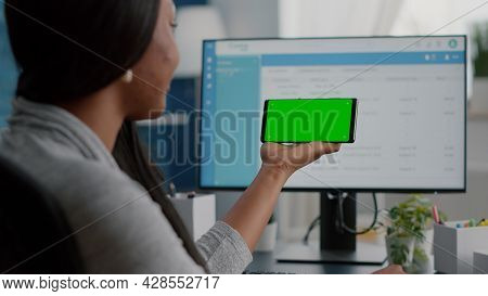 African American Student Working Remote From Home Looking With Mock Up Green Screen Chroma Key Phone