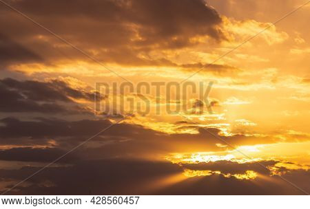 The Sun Was Shining Golden Yellow Through The Many Clouds In The Evening.
