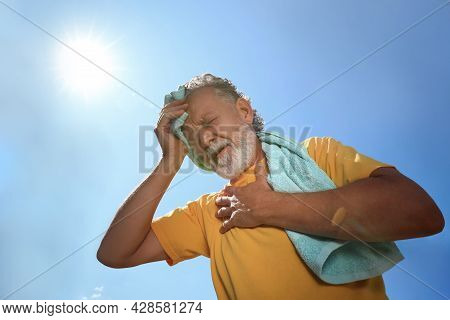 Senior Man With Towel Suffering From Heat Stroke Outdoors, Low Angle View