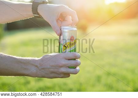 Man's Hands Open A Tin Can Of Schweppes In The Sunlight. Jar Of Schweppes In Men's Hands - Izmail, U