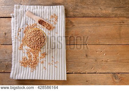 Wholegrain Uncooked Raw Spelt Farro In A Bowl With Napkin On The Wooden Table
