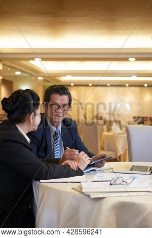 Senior Business Partners Meeting At Restaurant Table To Dicuss Contract Term And Sign Documents