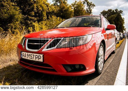 Chernigov, Ukraine - July 24, 2021: Saab Cars On The Road. Red Saab 9-3 Car On The Background Of Tre