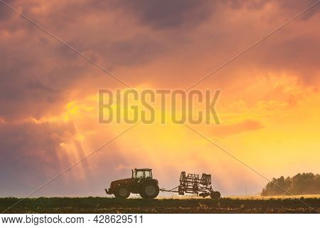 Tractor On Road In Spring Season. Beginning Of Agricultural Spring Season. Cultivator Mounted On Tra