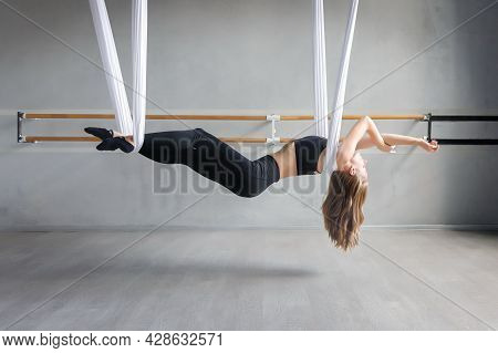 Young Slim Womann Doing Fly Yoga Hanging On Strap Or Hammock In Gym