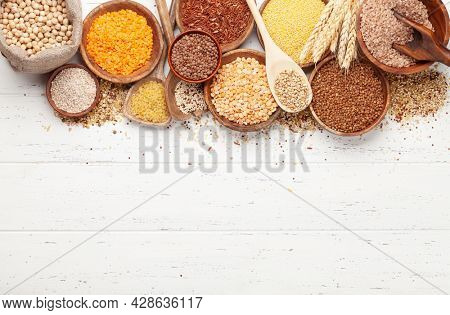 Gluten free cereals. Rice, buckwheat, corn groats, quinoa and millet in wooden bowls. Top view flat lay with copy space