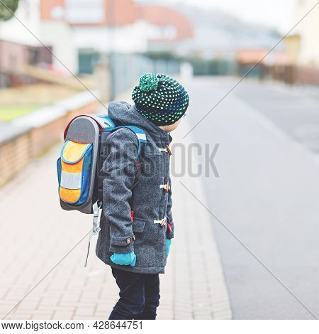 Little Kid Boy With Eye Glasses Walking From The School. Child On A Street. Preschooler Wearing Warm