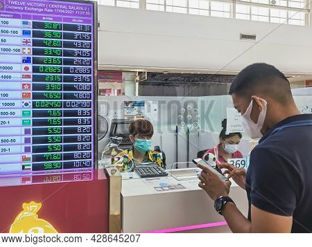 Nakhon Pathom, Thailand-april 17,2021 : Cashier Staff Wears Protective Mask Withdrawing Money For Cu